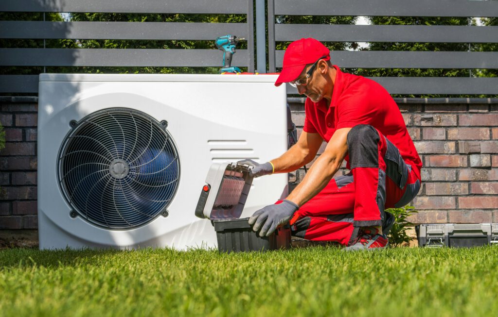 Techniker richtet die Außeneinheit einer Wärmepumpe ein