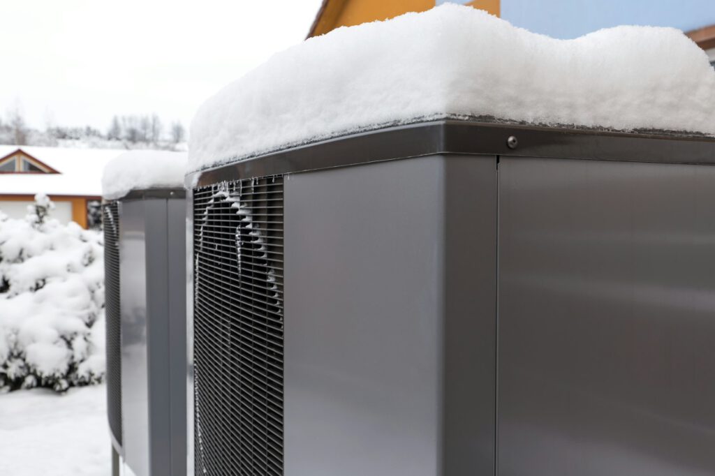Schnee auf der Außeneinheit einer Wärmepumpe
